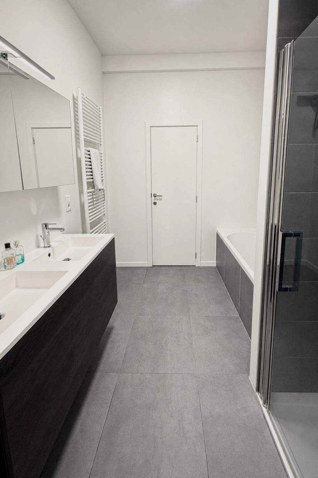 Badkamer met bad, douche en dubbele wastafel