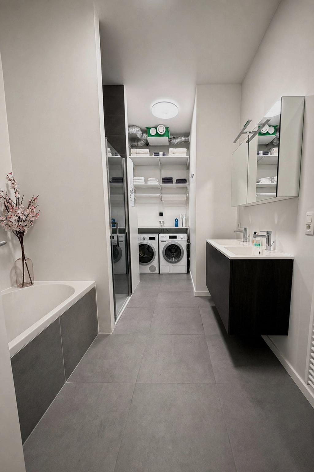 Badkamer met bad, douche en dubbele wastafel